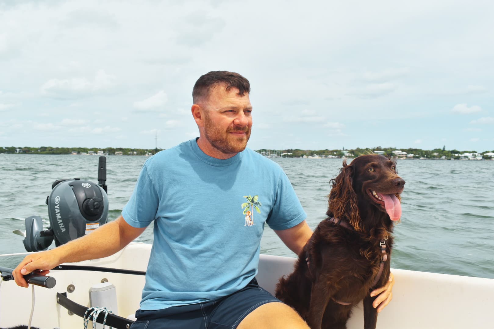 Jeremy Hansen, founder of Marlin Sites, driving his sailboat with his dog Dobbie.